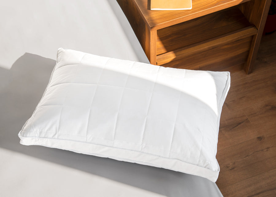 Natural Quilted Feather Pillow on bed aerial product image