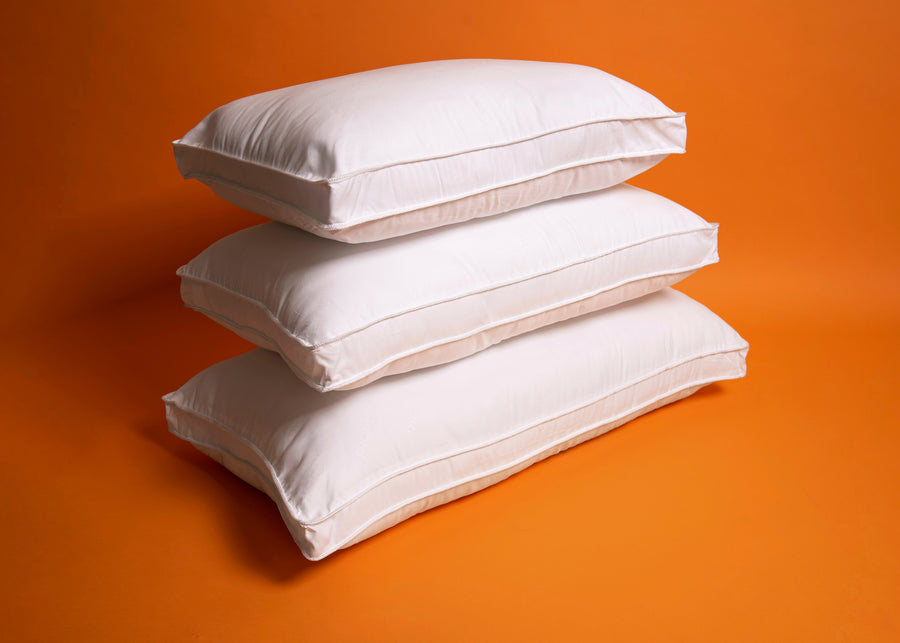 white antimicrobial gusseted pillows stacked